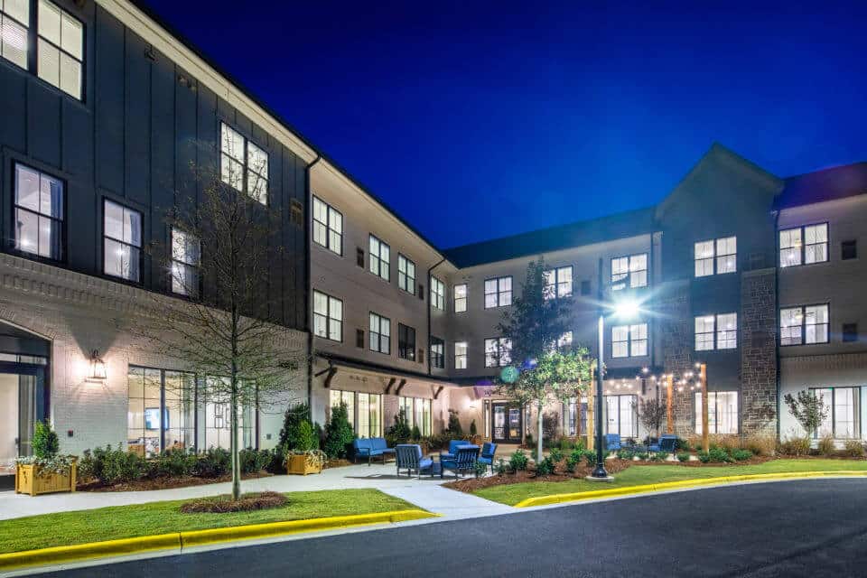 Rear exterior view of Longleaf Liberty Park at night with lights on and vivid blue skies