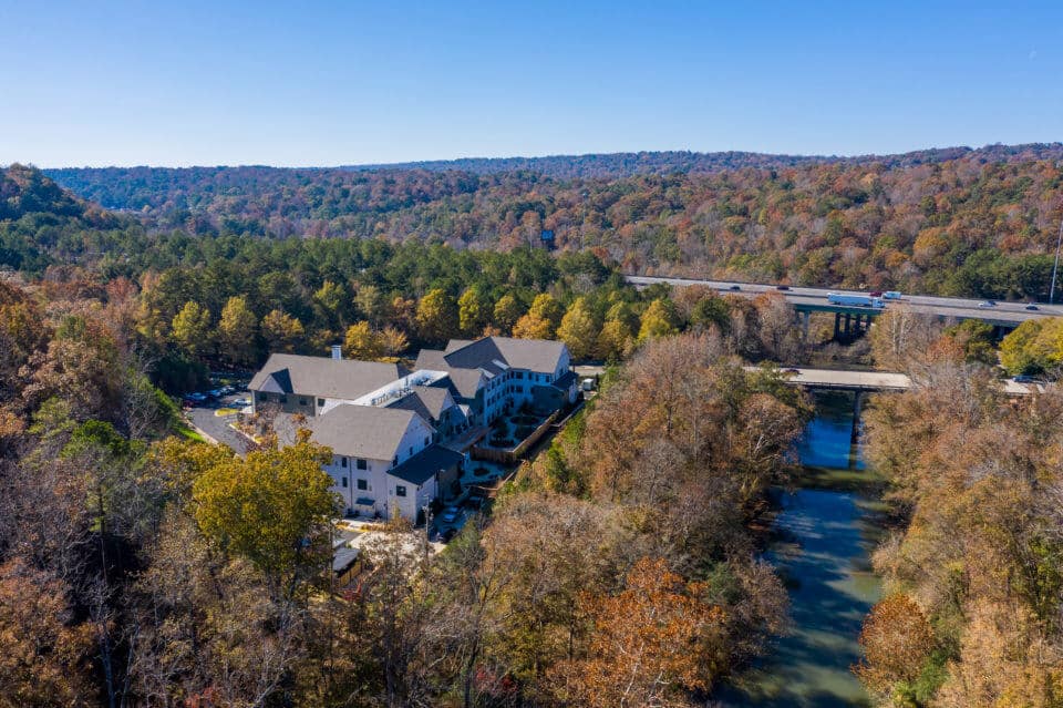 Aerial view of Longleaf community with river view to the right and community to the left surrounded by trees with fall colors