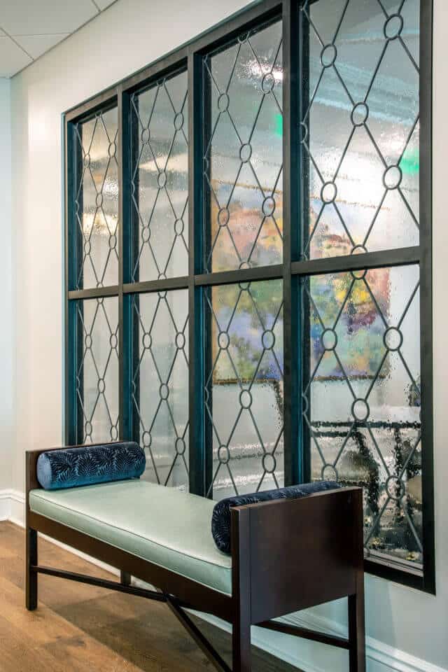 Windows with bubble glass and black diamond shape design looking into Longleaf dining room with bench in front