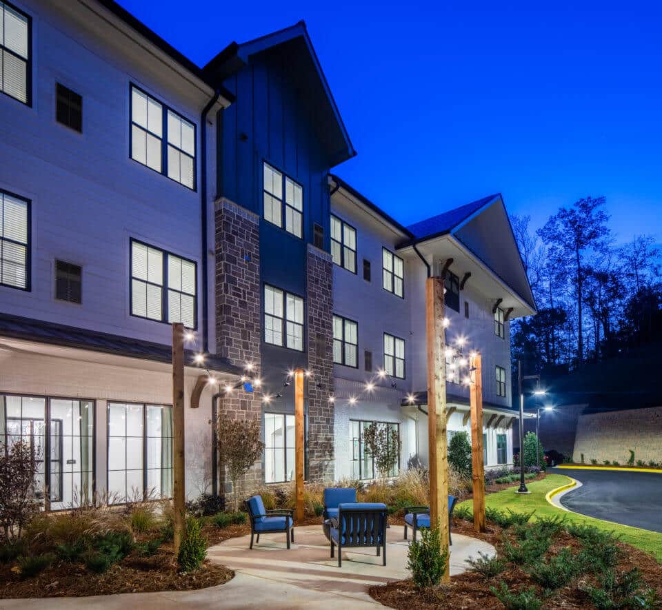 Rear exterior view of Longleaf Liberty Park at night with lights on and vivid blue skies