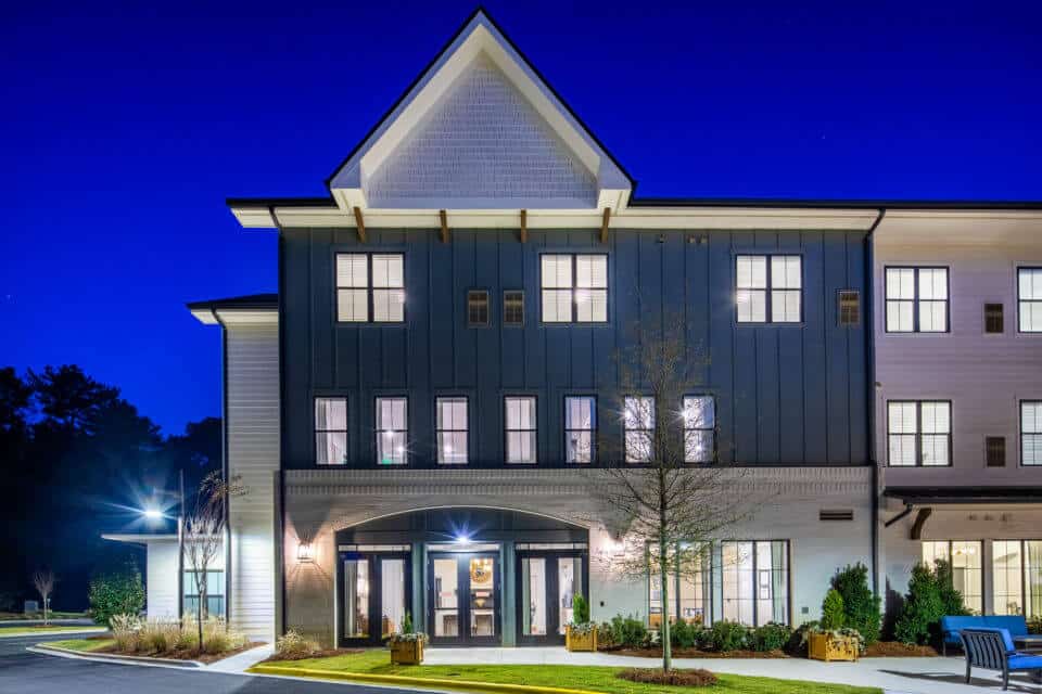 Rear exterior view of Longleaf Liberty Park at night with lights on and vivid blue skies