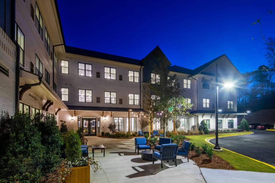 Rear exterior view of Longleaf Liberty Park at night with lights on and vivid blue skies