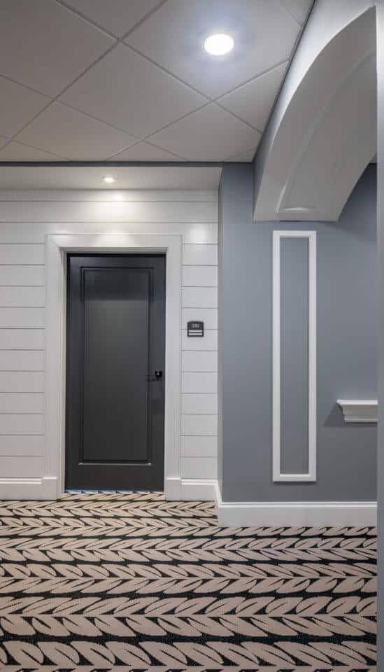 Longleaf hallway with white walls and residents' blue doors at left, gray walls at right of door