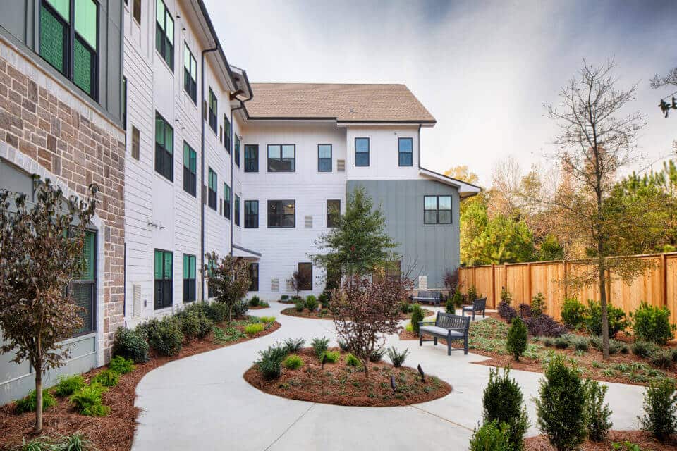 Longleaf patio view of landscaping, benches and wooden privacy fence at right