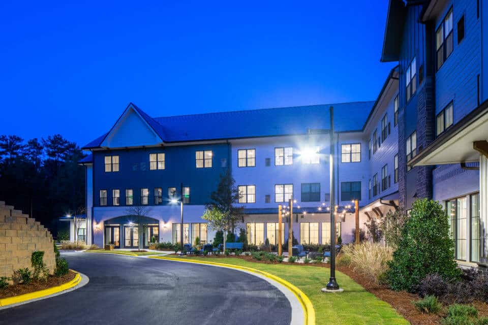 Rear exterior view of Longleaf Liberty Park at night with lights on and vivid blue skies