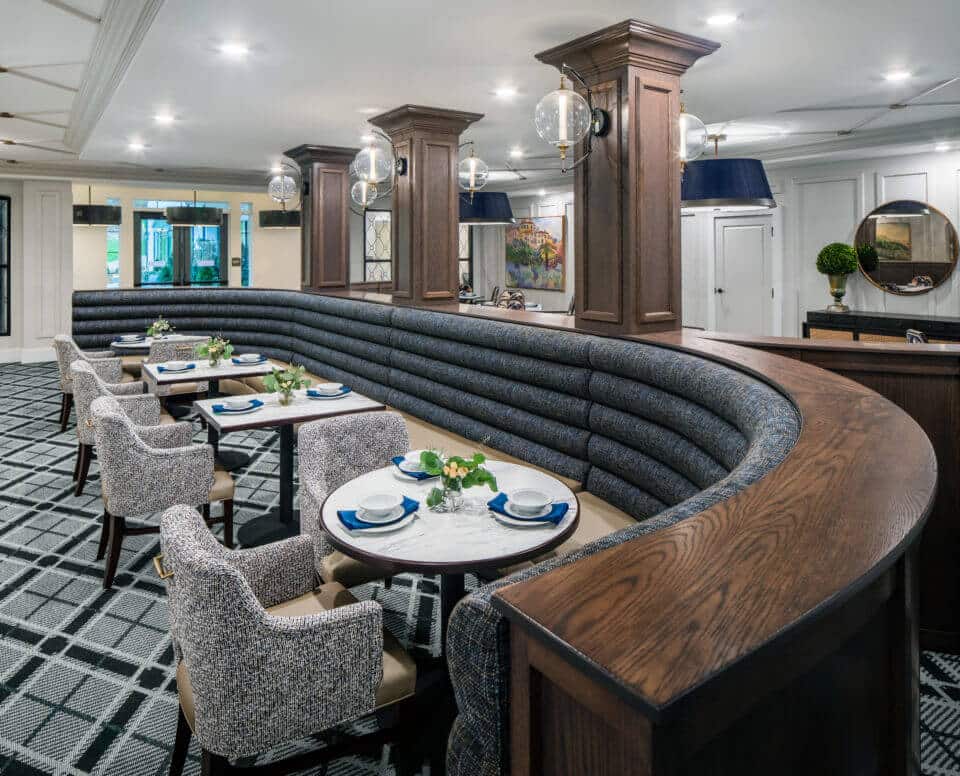 Longleaf main dining room blue and beige curved booth, tables and chairs with wood columns and globe light fixtures above