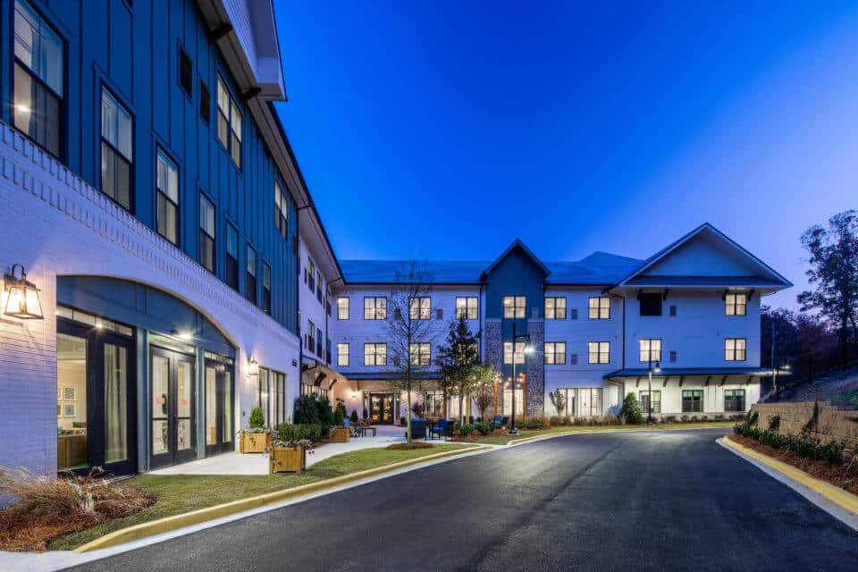 Rear exterior view of Longleaf Liberty Park at night with lights on and vivid blue skies