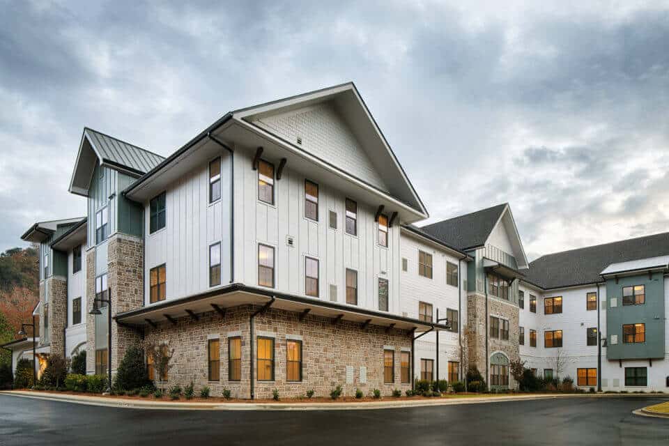 Exterior rear view of Longleaf Liberty Park at dusk with lights on and cloudy skies