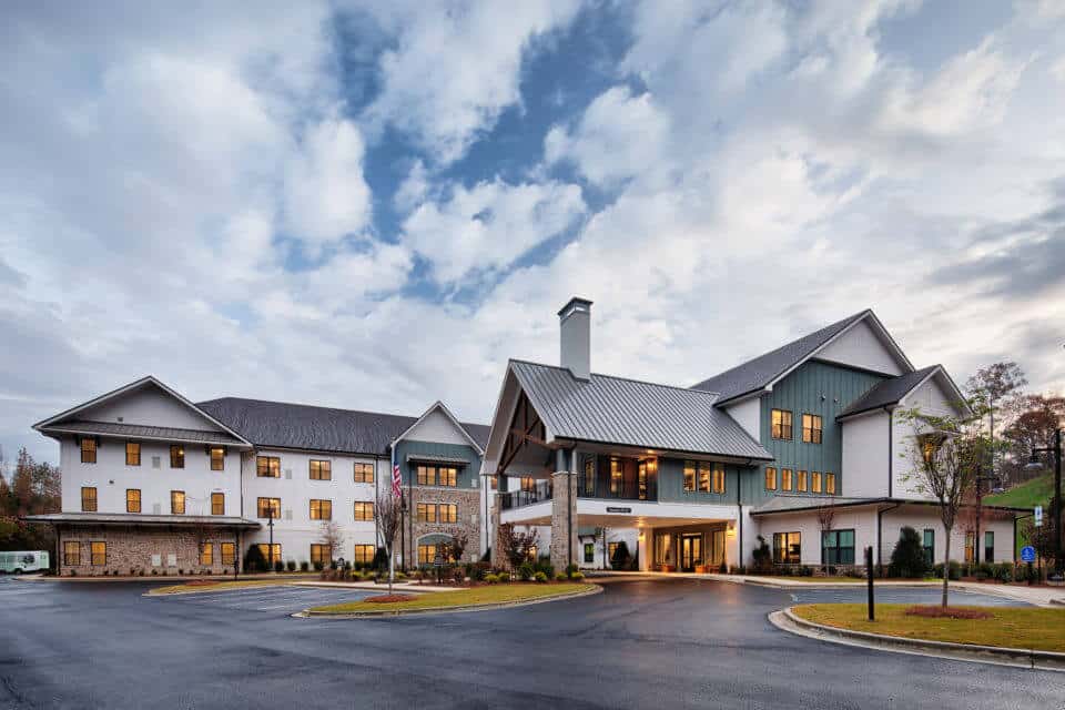 Exterior front view of Longleaf Liberty Park at dusk with lights on and blue skies with white clouds